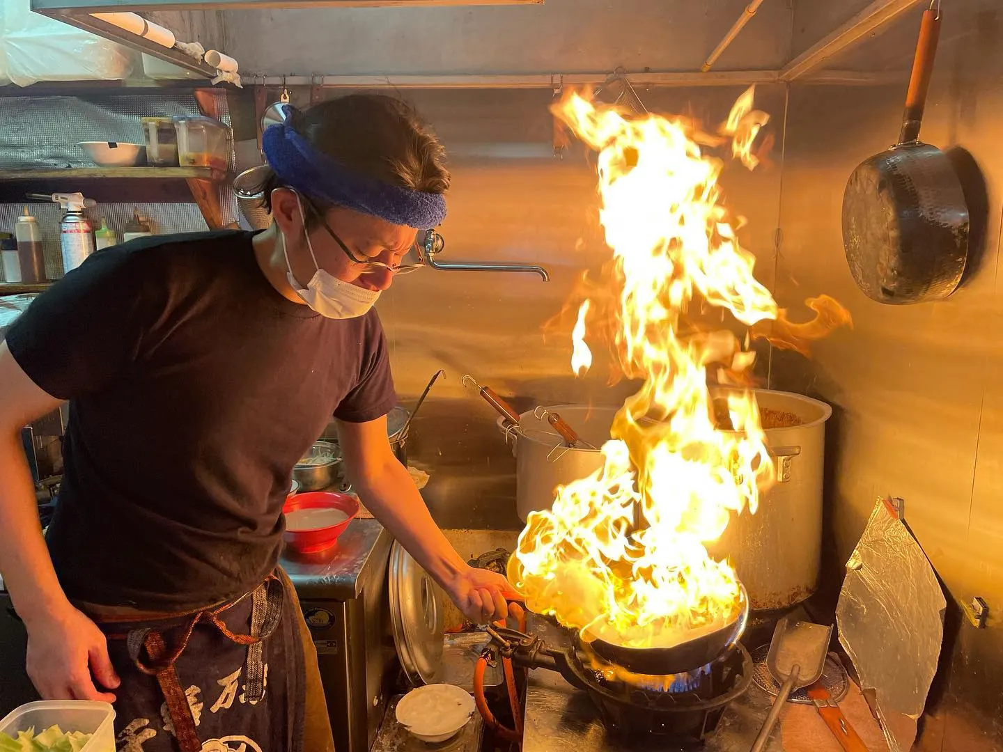 炎の上がる中華鍋をふる大将